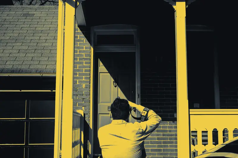 An estimator photographing storm damage on a brick house