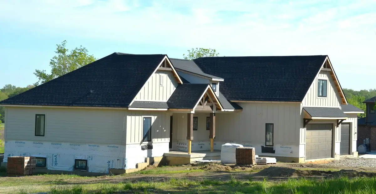 A newly built two-storey house with a fresh charcoal shingle roof
