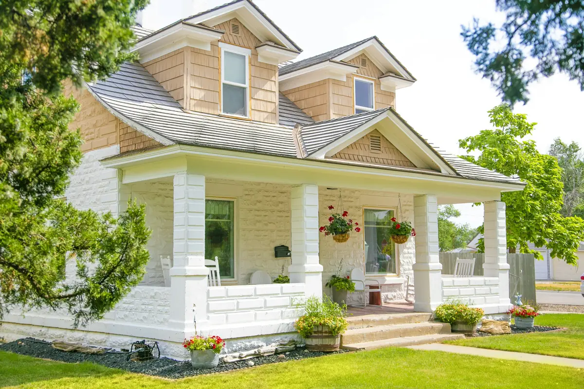 Cream craftsman house with dormers and a wide porch