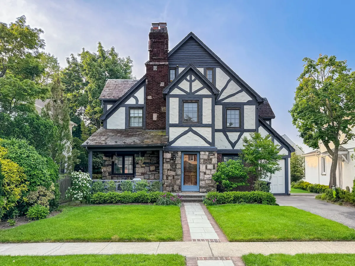 Tudor style home with a steep roof and brick chimney